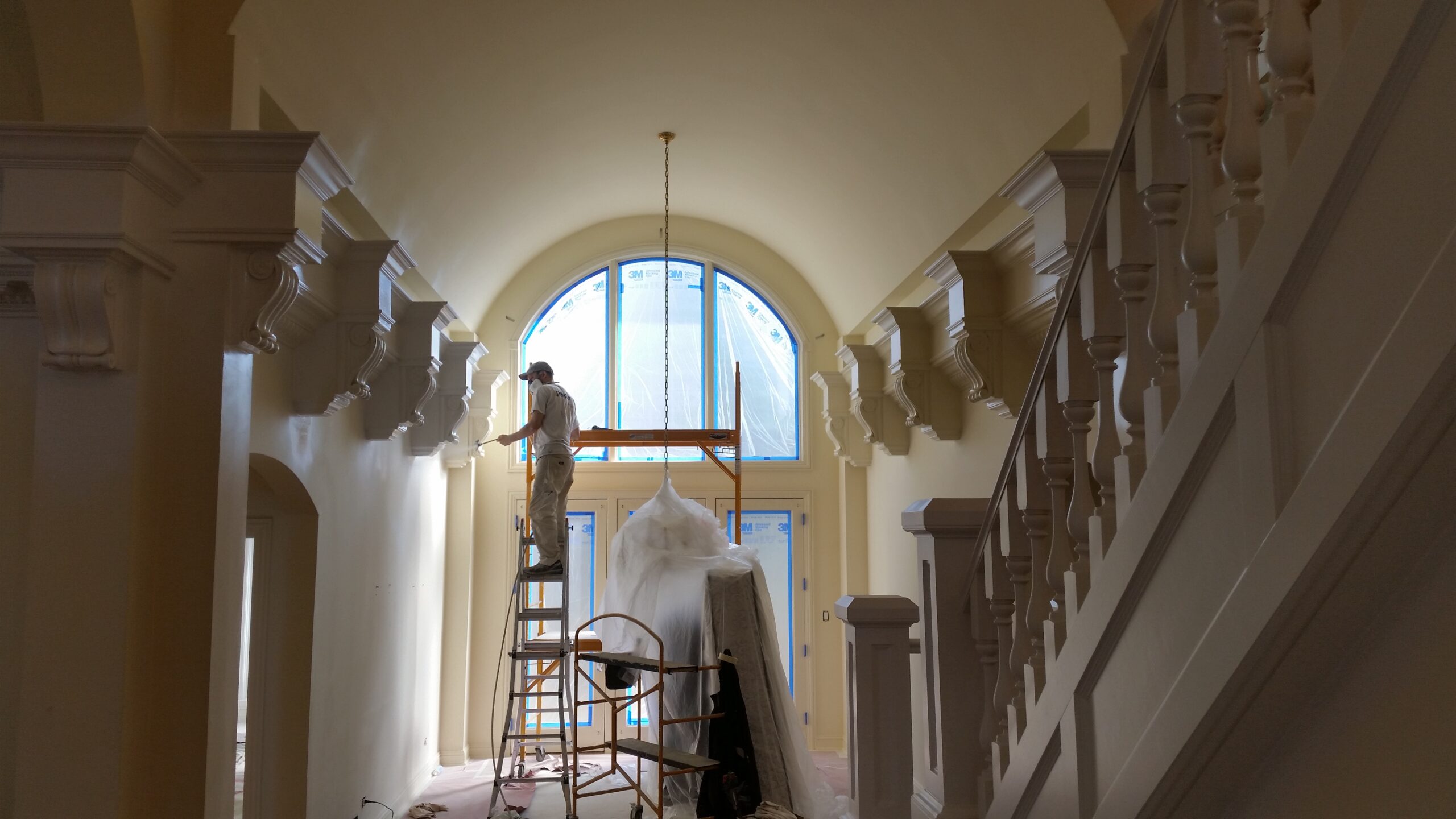 Artisons Painting craftsman repairing plaster gables on a ladder